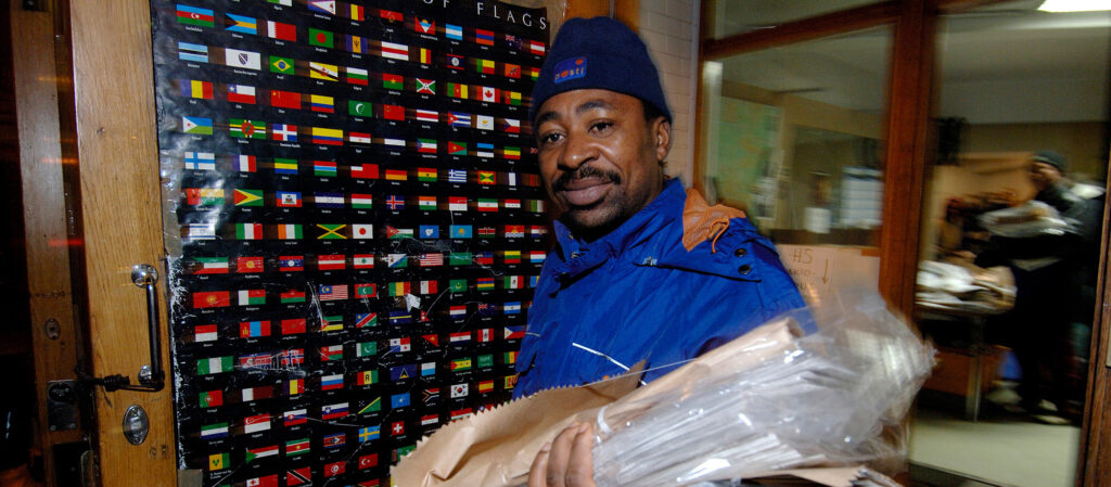 A man in a blue uniform holding a package.